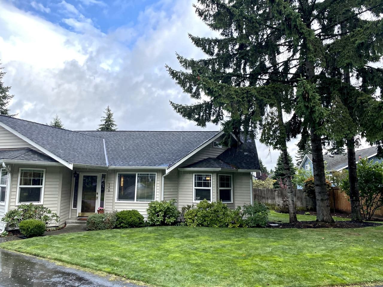 A home with a freshly soft-washed roof, clean shingles, and clear gutters